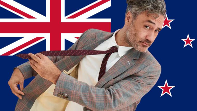 Taika Waititi in front of the New Zealand Flag
