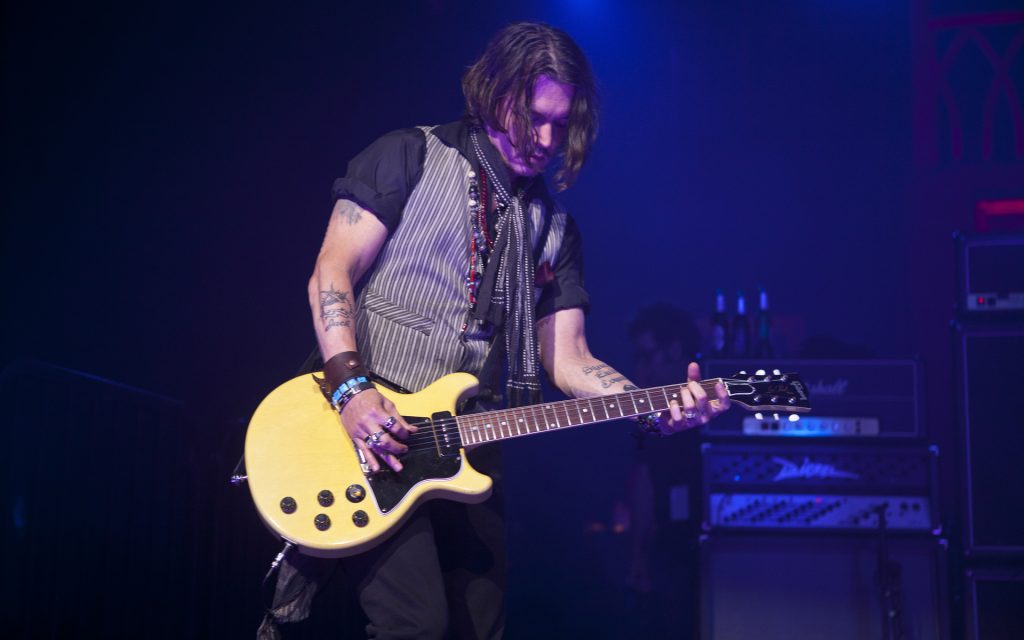 Johnny Depp performing at a concert (Yes, he indeed plays well).