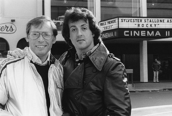 Stallone poses with producer Irwin Winkler in front of theatres playing Rocky