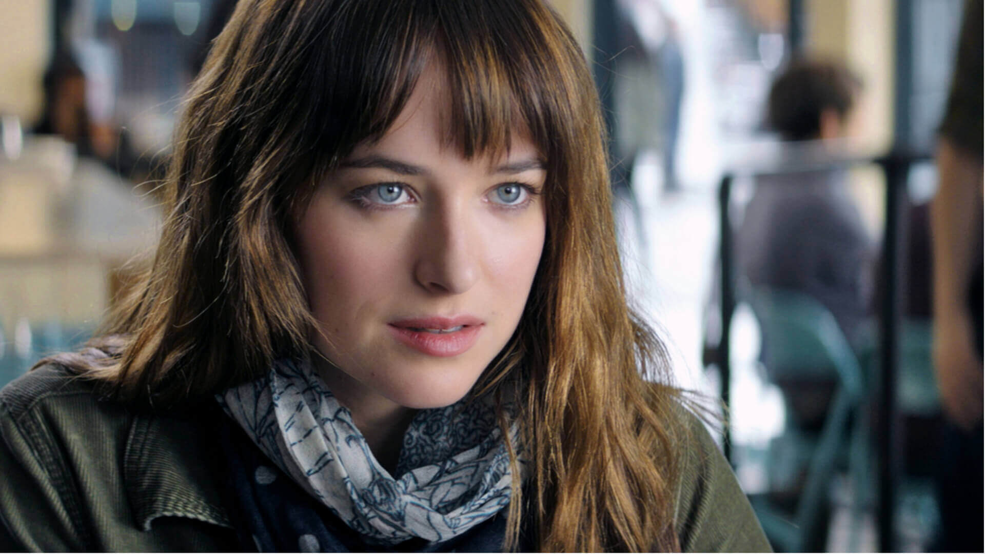 Dakota Johnson looking attentively in a still from Fifty Shades of Grey