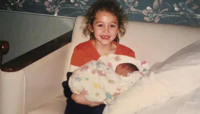 Kid Miley Cyrus holding her sister Noah Cyrus