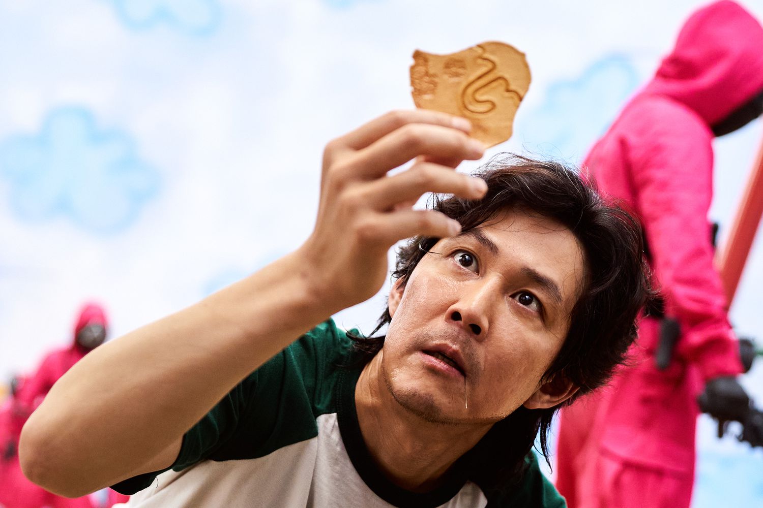Lee Jung-jae looking at his umbrella dalgona cookie in Squid Game series